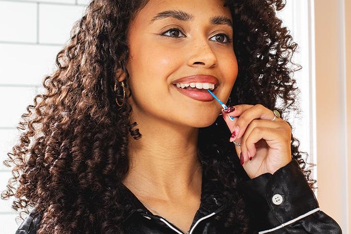Lady using Wisdom Clean Between rubber (wire free) interdental brush